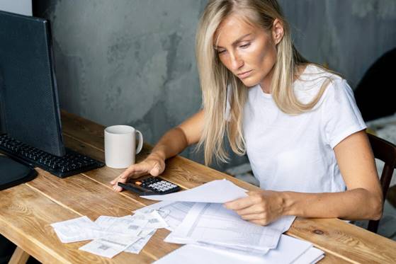 a-blonde-woman-sits-at-a-desk-and-works-with-docum-67VPV3V